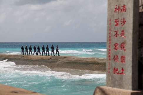 PLA Navy troops patrol near a sign in the Spratly Islands, known in China as the Nansha Islands. The sign reads: “Nansha is our national land, sacred and inviolable.” Photo: Reuters