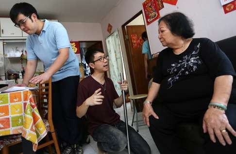 Members of social enterprise Longevity Design House take measurements for a sofa handle for 74-year-old Chan Cheung-tai in her home in Tsing Yi. Photo: Jonathan Wong