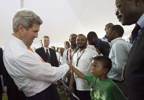 John Kerry, US secretary of state, shakes hands with a boy as he meets US embassy staff and their families in Kinshasa in 2014. Photo: Reuters