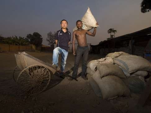 Zhang, a Chinese middleman who buys copper and cobalt from local miners in Katanga Province in Congo to sell on to China, poses with one of his employees at his warehouse in a mining town west of Lubumbashi. Photo: Luis de las Alas.
