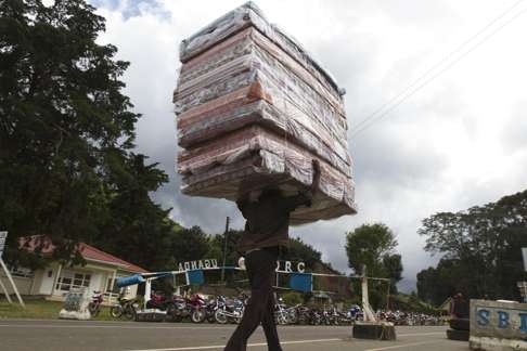 A man carries mattresses from Uganda into the Democratic Republic of Congo. Photo: AFP