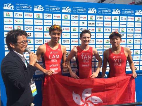 Michael Lam, James Tan and Mark Yu Shing-him show off the bauhinia flag. Photo: SCMP Pictures (Handout)