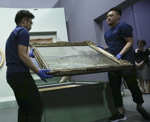 Museum staff unpack one of the works by Claude Monet ahead of the exhibition’s opening. Photo: Jonathan Wong