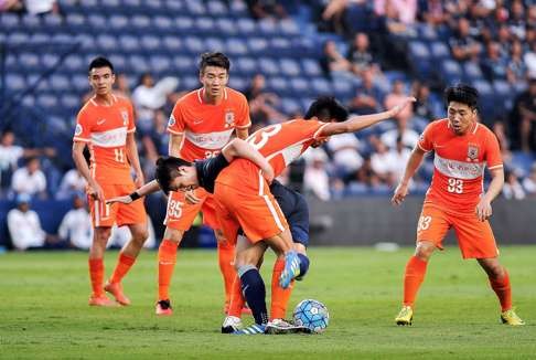Shangdong Luneng's Zhang Chi (C, #13) fights for the ball with an unidentified Buriram United player during their AFC champions league first round football match in Buriram on May 4, 2016. / AFP PHOTO / WATTHANA CHANCHAROEN