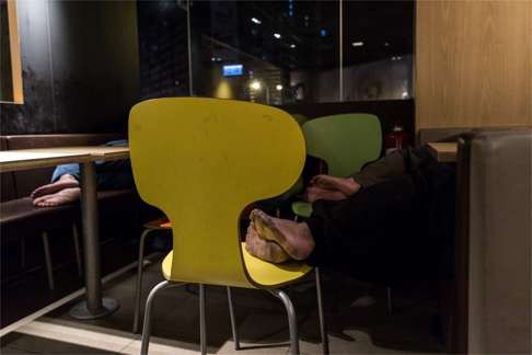 People sleeping in a restaurant in Kowloon, Hong Kong. Photo: AFP