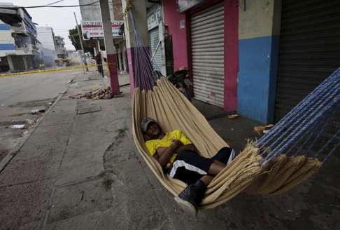 Someone sleeping in a hammock on a street in Portoviejo, Ecuador. Photo: Reuters