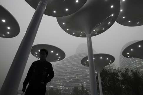 A man walks in the Wangjing area in Beijing against a backdrop of heavily polluted air on November 30, 2015. Photo: Simon Song