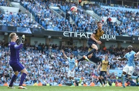 Arsenal’s Laurent Koscielny heads an effort at City goalkeeper Joe Hart. Photo: AFP