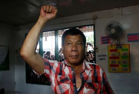 Presidential candidate Rodrigo Duterte raises a clenched fist before casting his vote in Davao city on Monday. Photo: Reuters