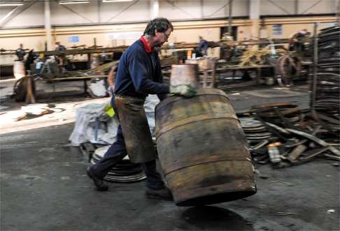 Coopers work on whisky casks at the Speyside Cooperage in Craigellachie, Scotland. Photo: Alamy