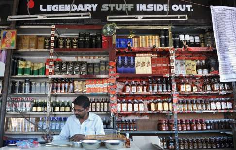 An employee does a stock check at an alcohol store in Hyderabad, India. Influencing voters through illicit liquor and cash is an age-old trick across the country, despite heavy penalties prescribed by the Election Commission against vote-buying. Photo: AFP