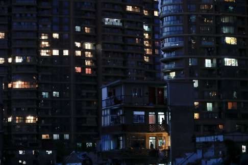 An old house is seen in front of new apartment buildings in Guangfuli neighbourhood, in Shanghai. Photo: Reuters