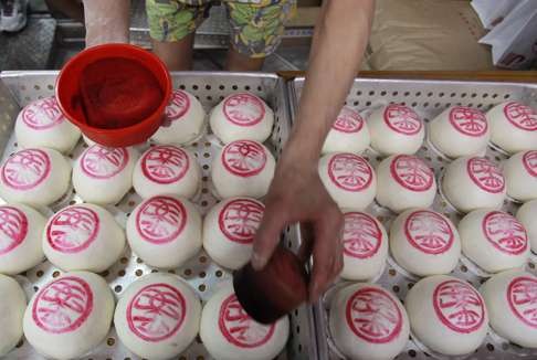 A worker at Grand Plaza Cake Shop puts the final touches on buns prepared for the festival last year.