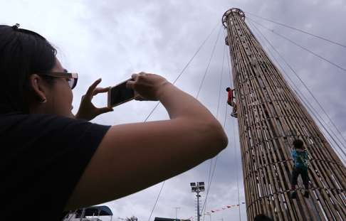 Those feeling brave enough climb a bun tower outside Cheung Chau Pak Tai Temple Playground during last year’s festival.