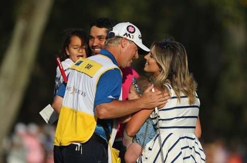 Day is congratulated by his caddy and his family after the win. Photo: AFP