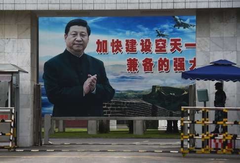 A soldier stands guard in front of a huge portrait of President Xi Jinping at the entrance to a military base in Guilin, Guangxi. While he is widely admired in China, critics view Xi as a dictator who rejects consensus. Photo: AFP