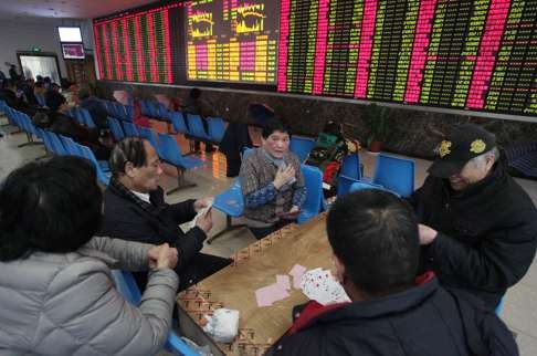 Investors play cards at a trading hall in Shanghai. If China experiences a major financial crisis, commodity prices could spiral even lower. Photo: Xinhua