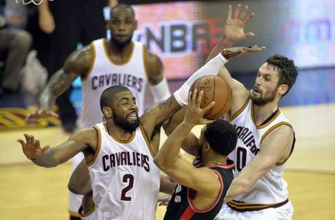 The Cavaliers’ Kyrie Irving and Kevin Love defend against the Raptors’ Cory Joseph. Photo: USA Today