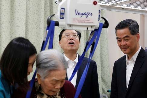 Zhang Dejiang checks a device assisting a woman to walk at an aged care complex in Hong Kong. Photo: Reuters