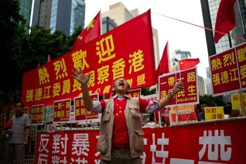 A mainland China supporter shouts in front of pro-Beijing slogans in Hong Kong during the second day of Zhang Dejiang’s visit. Photo: AFP