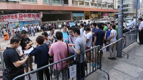Potential homebuyers lining up for subsidised flats. Prices are finally dropping, but they’re still unaffordable. Photo: Edward Wong
