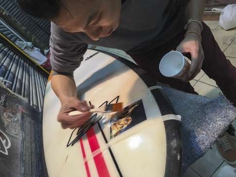 A surfboard is repaired at Swell Water Sports Workshop in Shau Kei Wan.