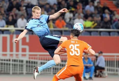 Matthew Simon of Sydney FC fights for the ball with Dai Lin of Shangdong Luneng. Photo: AFP