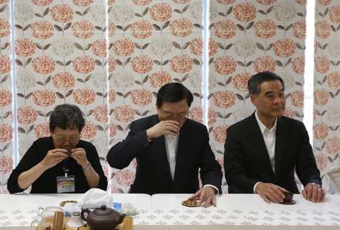 Zhang (centre) sips tea next to Chief Executive Leung Chun-ying and a resident at an elderly care home. Photo: EPA