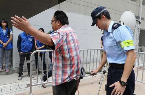 Police doing security checks at the media area at On Tat Estate. Photo: Dickson Lee