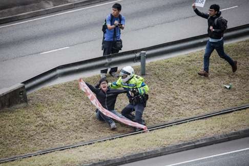 Demosisto member Oscar Lai were subdued by police officers while trying to get close to Zhang Dejiang's motorcade. Photo: SCMP Pictures