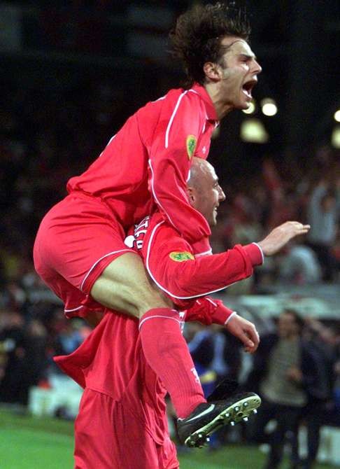 Patrik Berger jumps on Gary McAllister after he sealed the win. Photo: Reuters