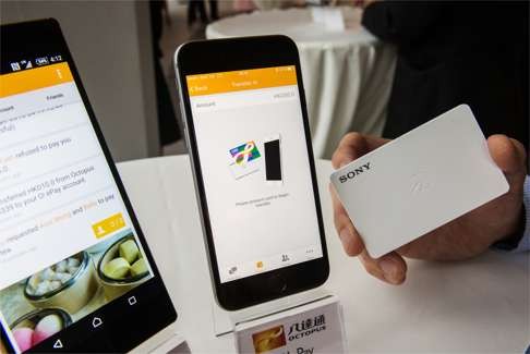 An Octopus card reader is seen next to smartphones displaying the O! ePay mobile payment service. Photo: Bloomberg