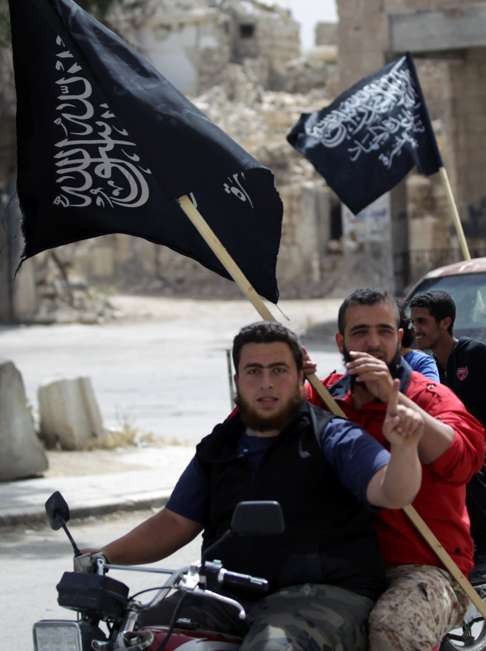 Men on motorbike carrying al-Nusra Front flags. Photo: Reuters