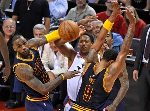Toronto Raptors guard DeMar DeRozan passes the ball past Cleveland Cavaliers forwards LeBron James and Channing Frye. Photo: USA TODAY Sports