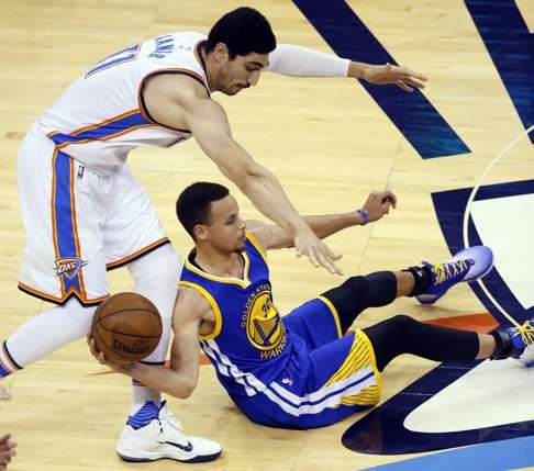 Golden State Warriors guard Stephen Curry (30) tries to pass a loose ball as Oklahoma City Thunder center Enes Kanter (11) defends. Photo: AP