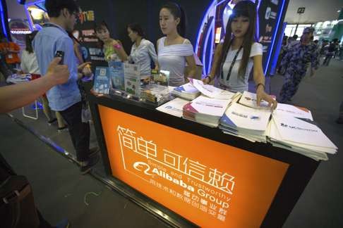A 2015 file photo showing staff members handing out brochures to visitors at the Alibaba booth at the Global Mobile Internet Conference in Beijing. Photo: AP
