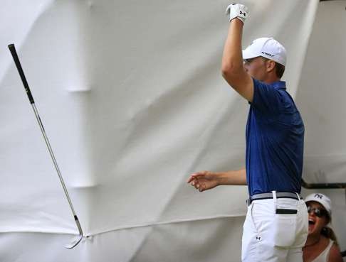 Spieth tosses his club after making a birdie from off the green on the 17th hole. Photo: TNS