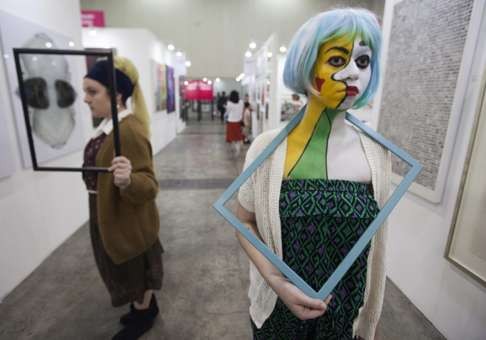 Two models at this year’s Affordable Art Fair in Hong Kong on its opening day. Photo: EPA