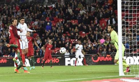 Chris Smalling scores the only goal of the game against Portugal. Photo: EPA