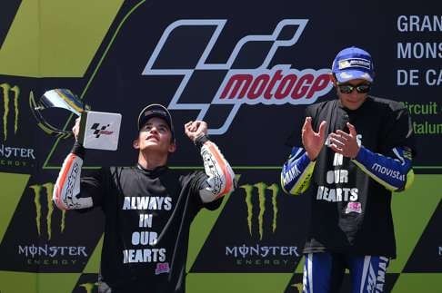 Italian rider Valentino Rossi applauds second-place Spanish rider Marc Marquez on the podium . Photo: AFP