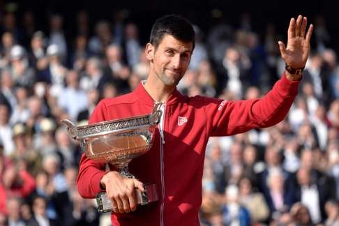 Serbia's Novak Djokovic poses with the trophy after winning the men's final match.