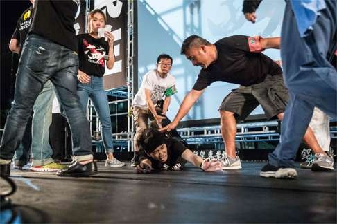 A man is restrained after running onto the stage and shouting pro-independence slogans during the candlelight vigil in Hong Kong, in commemoration of the Tiananmen crackdown. Photo: AFP