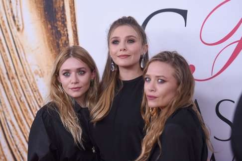 Elizabeth Olsen (centre) with Mary-Kate and Ashley Olsen. Photo: AFP