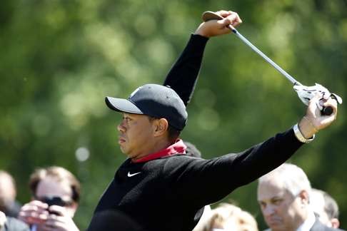 Tiger Woods stretches before hitting three ceremonial golf balls last month. Photo: AP