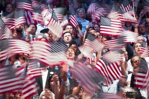 Attendees wave American flags before Hillary Clinton, the presumptive Democratic presidential nominee, speaks in Brooklyn, New York. The many Asians who think they understand the US after short visits to Wall Street and Las Vegas are wrong. Photo: Bloomberg