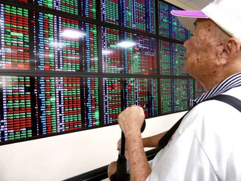 Keeping a close watch on Taiwan Stock Exchange movements on an electronic board at a brokerage in Taipei, 25 August 2015. Photo: EPA/DAVID CHANG