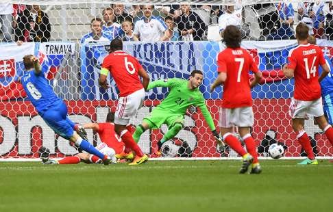 Slovakia's midfielder Ondrej Duda (L) shoots and scores his team's first goal during the Euro 2016 group B football match between Wales and Slovakia at the Stade de Bordeaux in Bordeaux on June 11, 2016. / AFP PHOTO / Joe KLAMAR