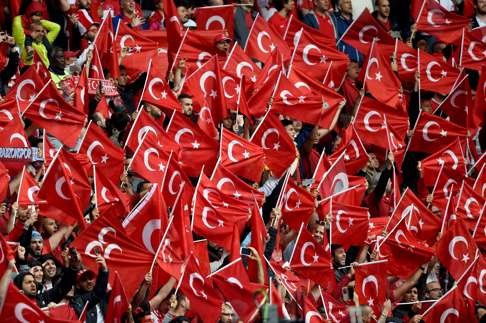 Turkey fans wave the national flag at the start of the Euro 2016 group D football match between Turkey and Croatia at Parc des Princes in Paris on June 12, 2016. / AFP PHOTO / BULENT KILIC