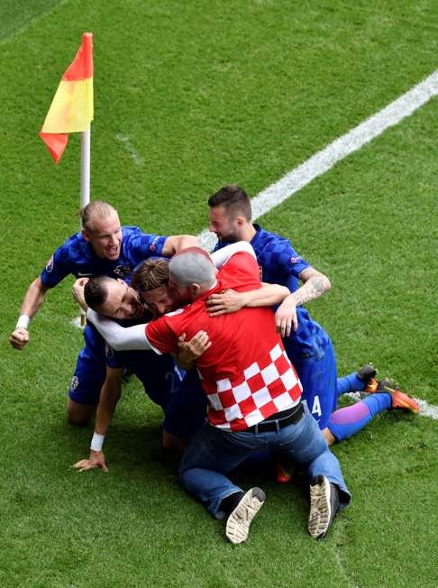 A fan enters onto the pitch to celebrates with Croatia's midfielder Luka Modric and his teammates. Photo: AFP