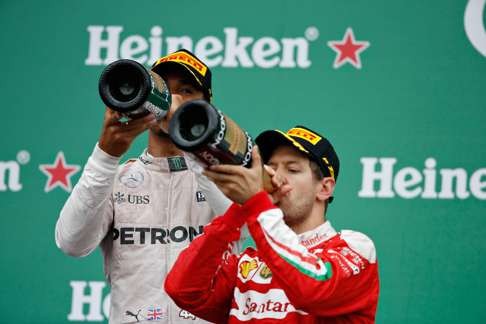 Lewis Hamilton and runner-up Sebastian Vettel enjoy the trappings of success. Photo: AFP
